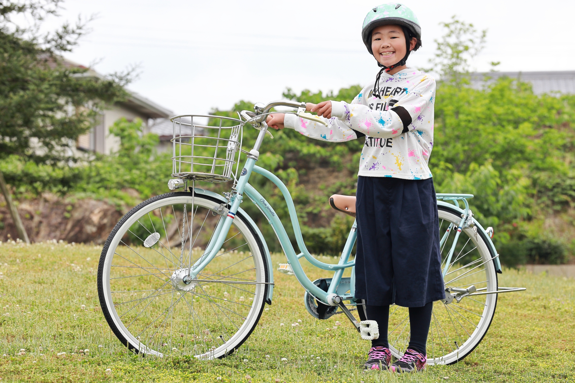 ヘルメットをかぶって自転車を持つ子供