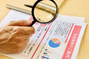 生命保険の案内資料虫眼鏡で確認する