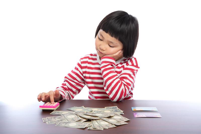 頰杖をついてお金の計算をする女の子